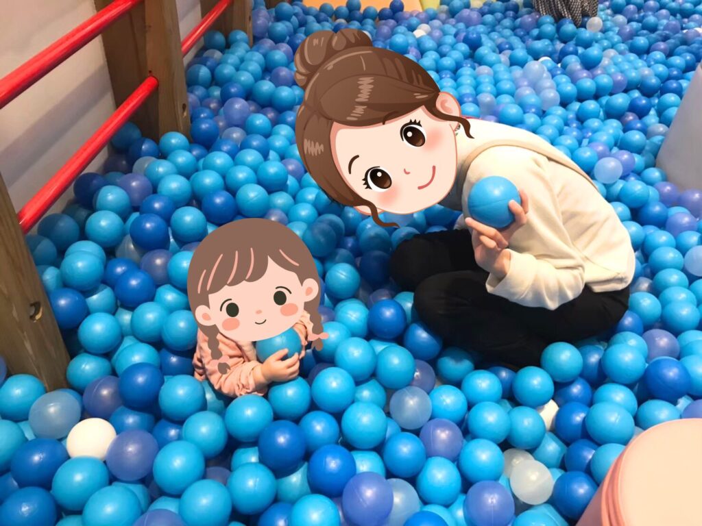 A parent and child playing together in ASOBono!'s blue ball-pit area