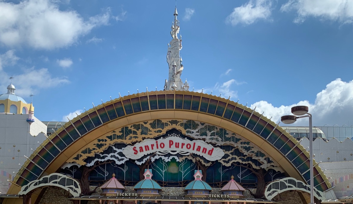 The rainbow-arched entrance gate of Sanrio Puroland with its white castle tower