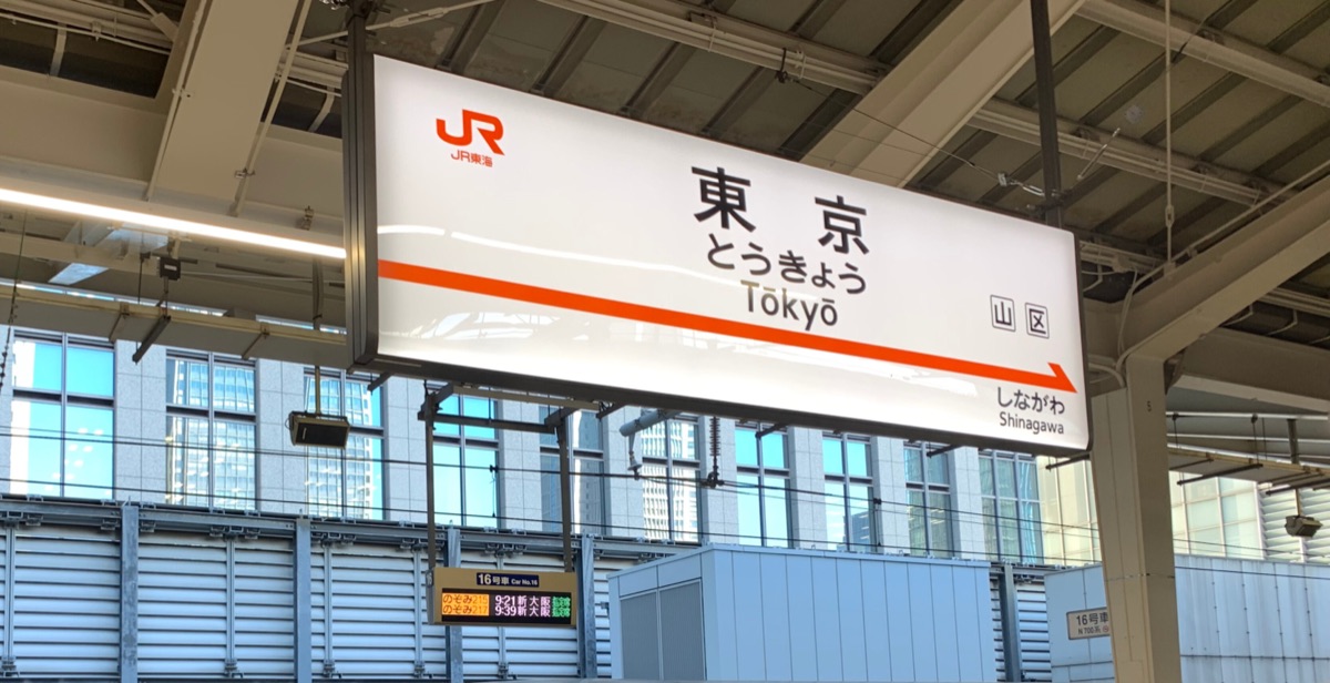 Tokyo Station sign on the Shinkansen platform with a bullet train waiting